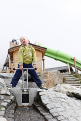 Child playing in a water circuit near the Swiss mountains.