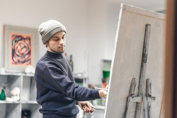 Concentrated student artist paints a picture of a brush at the host's art studio. Painting Concept....