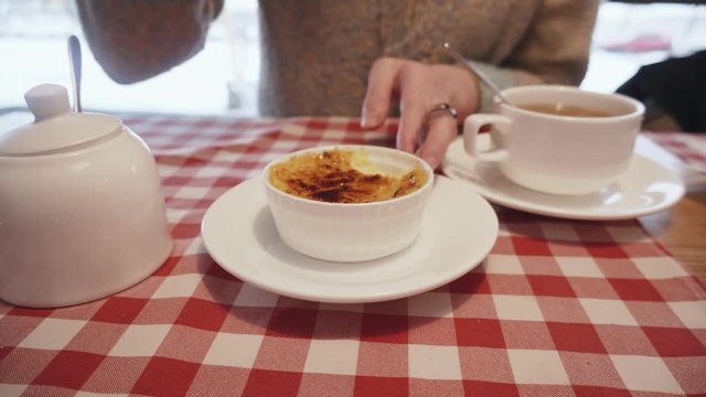 Gourmet girl, a young food blogger tastes the sweetest dessert creme brulee.