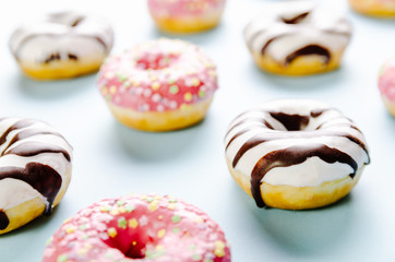 Donut with dark and white chocolate on the top on blue background. Selective focus.