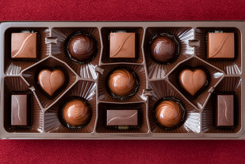 Box of assorted chocolates on a red background for Valentine’s Day