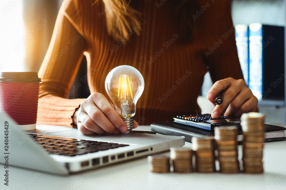 Poster business man hand holding lightbulb with using smartphone and calculator to calculate and money stac