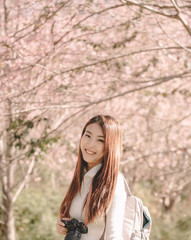 portrait of young asian woman with scenery of wild Himalayan cherry blossoms, trees, field and forest