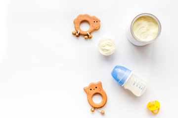 Craft toys for kids. Developing rattle for the smallest and baby bottle with milk. White background top view mock up