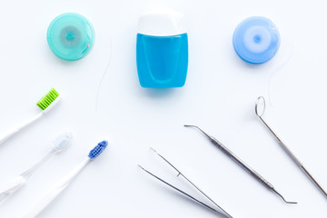 Daily oral hygiene for family. Toothbrush, dental floss and dentist instruments on white background top view