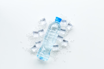 crashed ice cubes with bottle on white kitchen table top view mock up