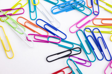 Multi-colored paper clips on white background, Closeup. Abstract.
