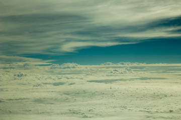 Fototapeta na wymiar White infinite valley of clouds against the blue sky and lines of clouds, view from a great height. only sky