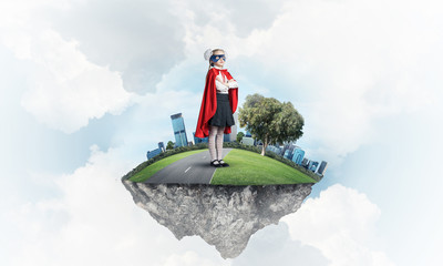 Girl power concept with cute kid guardian against cityscape back