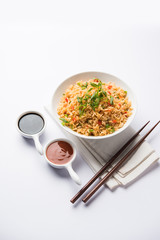 Schezwan Fried Rice Masala is a popular indo-chinese food served in a plate or bowl with chopsticks. selective focus