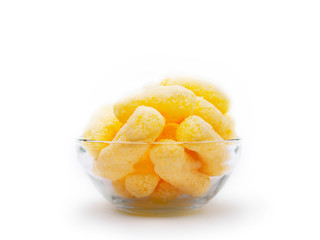 Yellow Corn Puffs in a Glass Bowl Isolated On White Background. Crunchy Flavored Puffed Snacks. Party, Movie, TV, Game Snacks.