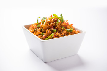 Schezwan Fried Rice Masala is a popular indo-chinese food served in a plate or bowl with chopsticks. selective focus