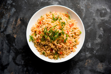 Schezwan Fried Rice Masala is a popular indo-chinese food served in a plate or bowl with...