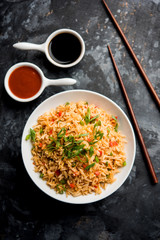 Schezwan Fried Rice Masala is a popular indo-chinese food served in a plate or bowl with chopsticks. selective focus
