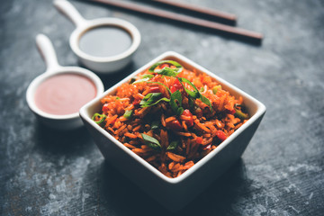 Schezwan Fried Rice Masala is a popular indo-chinese food served in a plate or bowl with chopsticks. selective focus