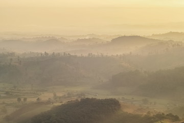 sunrise at Doi Mae Salong, beautiful mountains with many hills around with soft mist and yellow sun light in the sky background, Doi Mae Salong View Point, Chiang Rai, northern Thailand.