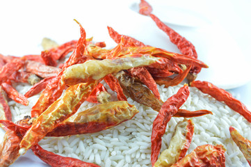 pile of rice and dried chilli on white background