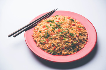Schezwan Fried Rice Masala is a popular indo-chinese food served in a plate or bowl with chopsticks. selective focus