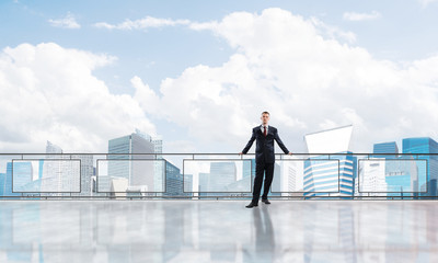 Sunrise above skyscrapers and businessman facing new day