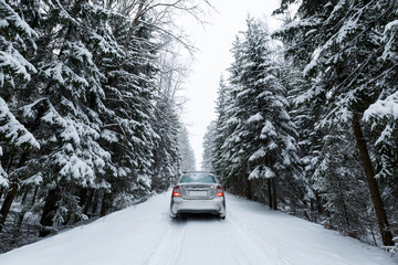 car snowy and frozen in the forest on the road. After the winter snowfall