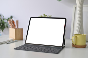 Workspace office table with mockup tablet and office supplies on office desk.