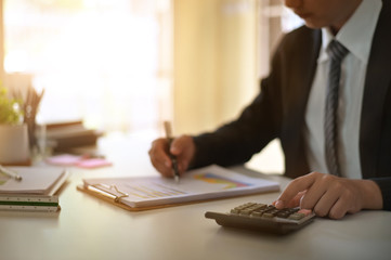 Fototapeta premium Businessman doing finances and calculate on office desk about cost at home office.