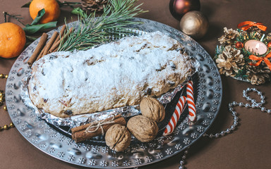 Stollen Christmas Cake on a brown background with glittering decorations