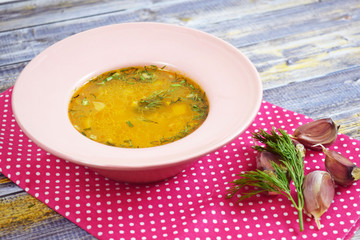Delicious hot soup with rice, garlic and hot pepper on wooden background.