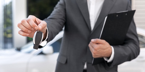 Successful business man offering a car key