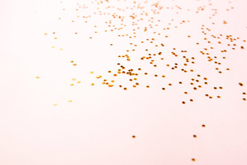Gold color confetti on pink
