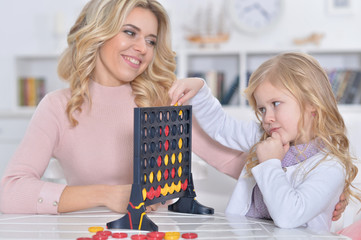Portrait of young woman and little girl playing with educational toy