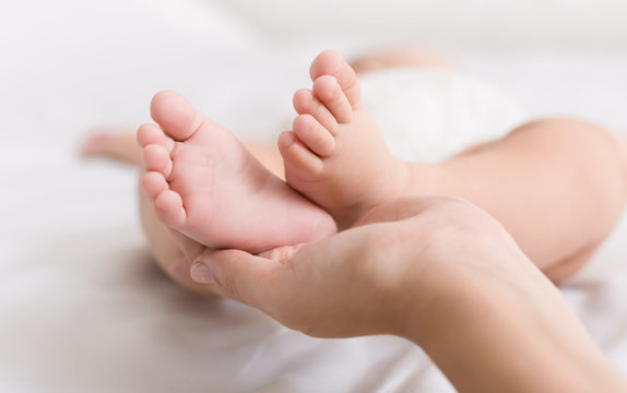 Little baby feet in mother hands closeup