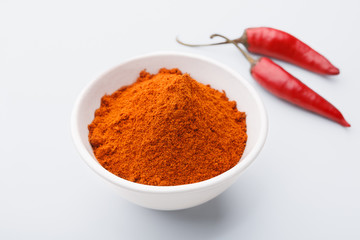 Red chilly powder in bowl over white background