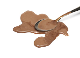Spilled chocolate milk puddle and metal spoon isolated on white background