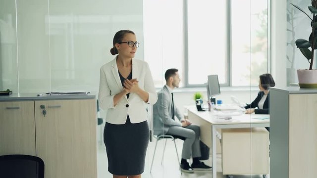 Stressed woman is standing in office room waiting for job interview expressing negative emotions fear and lack of confidence then walking to interviewer.