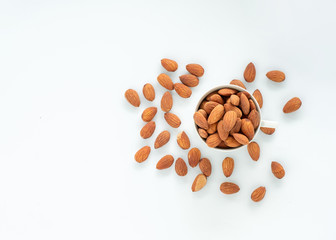Almonds in cup with fall on white background