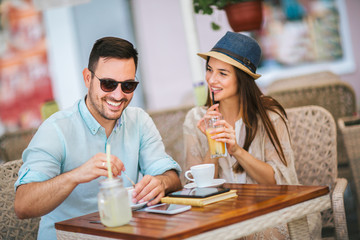 Beautiful loving couple sitting in a cafe enjoying in coffee and conversation, selective focus