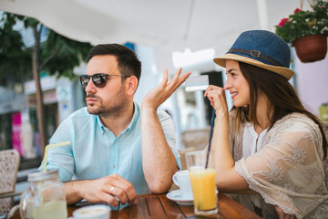 Beautiful loving couple sitting in a cafe enjoying in coffee and conversation, selective focus