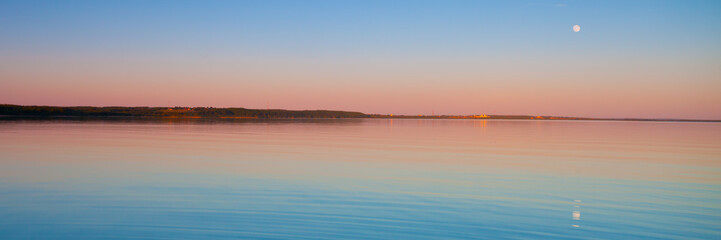 Fototapeta na wymiar Panorama of the turquoise dawn of the sky and water of pink and turquoise color, the sun rises