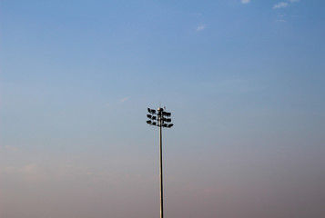 electric spotlight pole with sunset as background