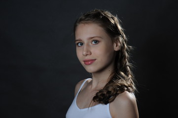 Naklejka premium Beautiful teenager girl. Studio portrait. Dark background