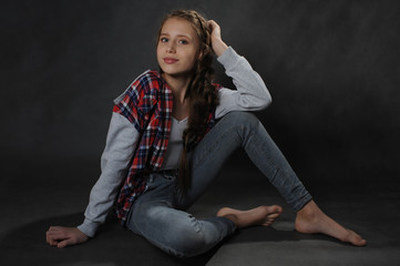 Beautiful teenager girl. Studio portrait. Dark background