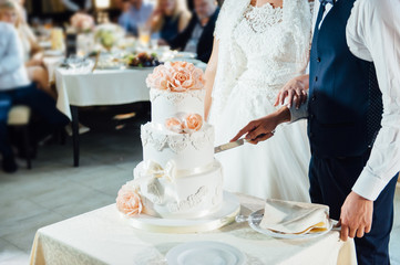 Wedding ceremony. Bride and groom cutting cake