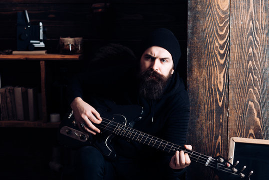 Music is fun. Hipster musician. Bearded man play the guitar. Rock guitarist playing music. Rock style man. Rock and roll music performer. Electric guitar player