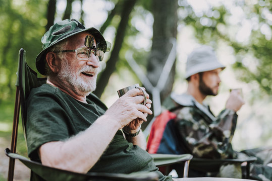 Positive Smiling Elderly Man Sitting In The Folding Chair