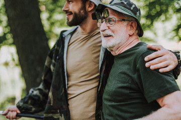 Fototapeta premium Cheerful elderly man resting with his adult son