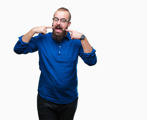 Fototapeta premium Young caucasian hipster man wearing glasses over isolated background smiling confident showing and pointing with fingers teeth and mouth. Health concept.
