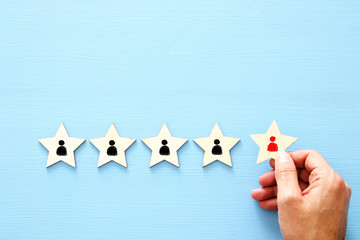 photo of 5 star symbols with people icons over wooden table ,human resources and management concept.