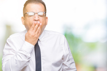 Middle age bussines arab man wearing glasses over isolated background bored yawning tired covering mouth with hand. Restless and sleepiness.