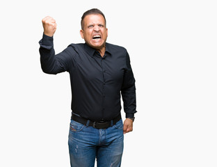 Handsome middle age arab business man over isolated background angry and mad raising fist...